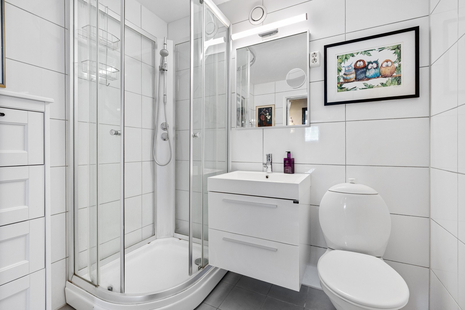 Det er seksjon med servant, gulvstående toalett, speil med belysning og dusjkabinett. Galleribilde