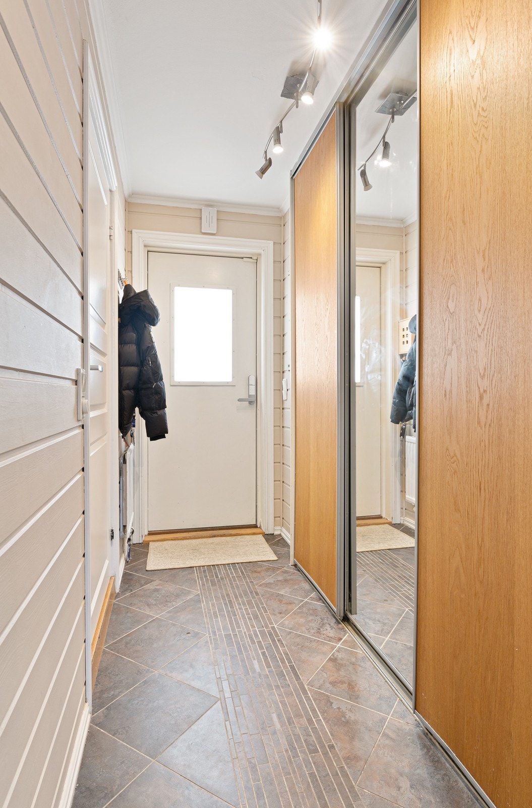 Lys og romslig entre med integrert skyvedørsgarderobe. Galleribilde