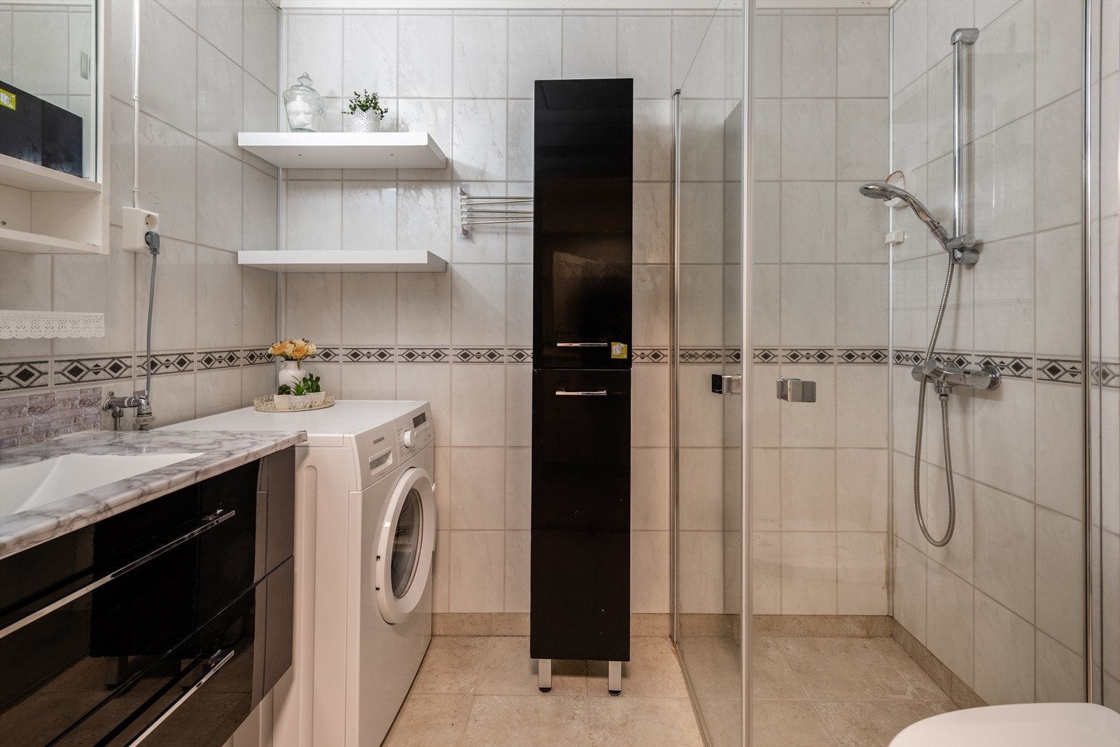 Bad med fliser på gulv og baderomsplater på vegger. Galleribilde