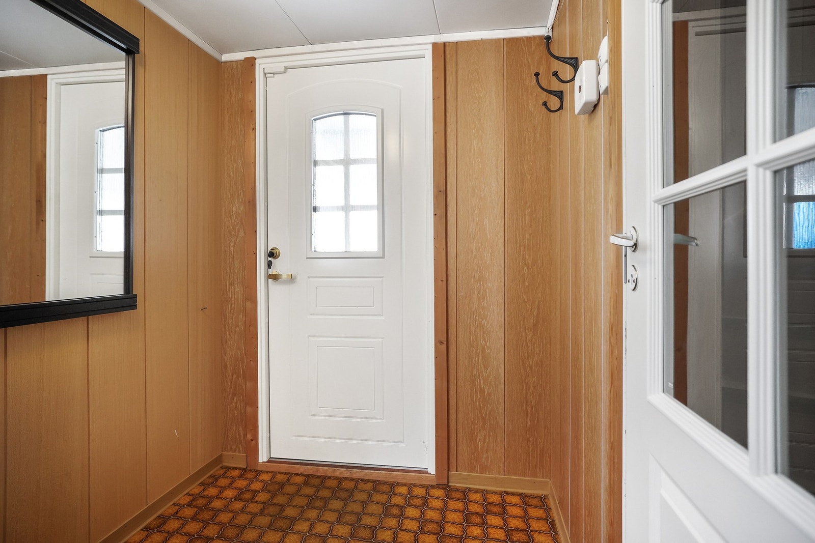 Entréen har en fin størrelse med plass til å henge fra seg på fastmonterte knagger. Galleribilde