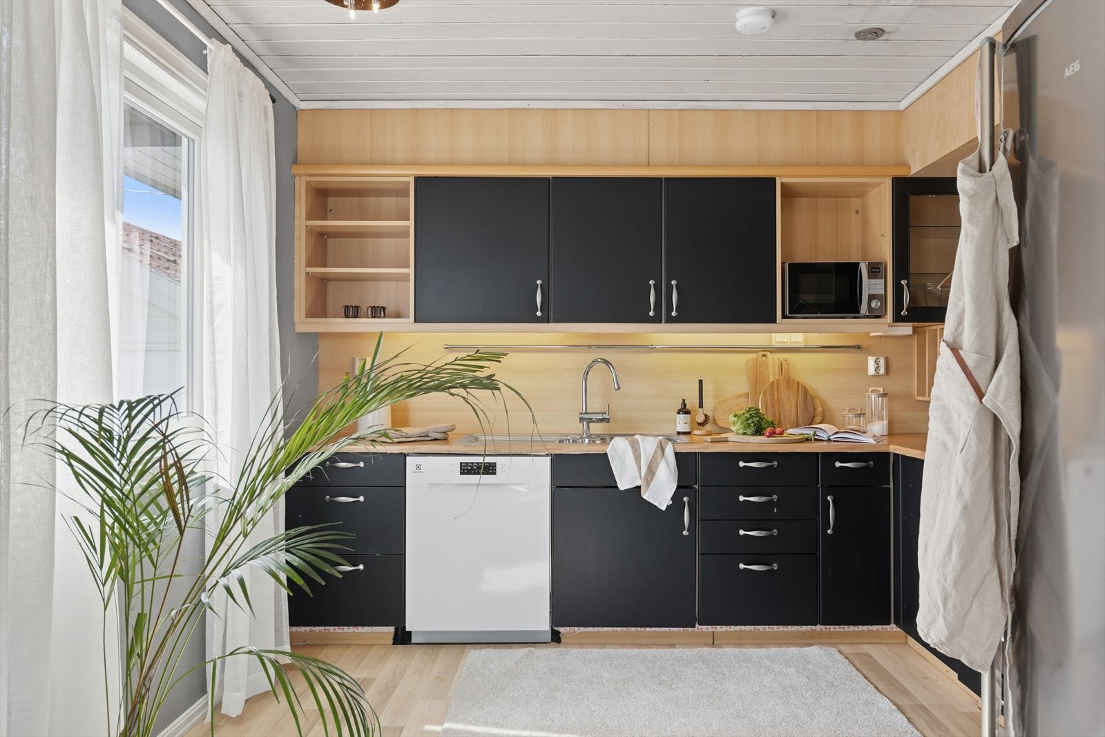 Kjøkkenet har en stilren og funksjonell innredning med god skap- og benkeplass. Frontene er mørke og står i kontrast til de lyse flatene ellers i rommet. Galleribilde