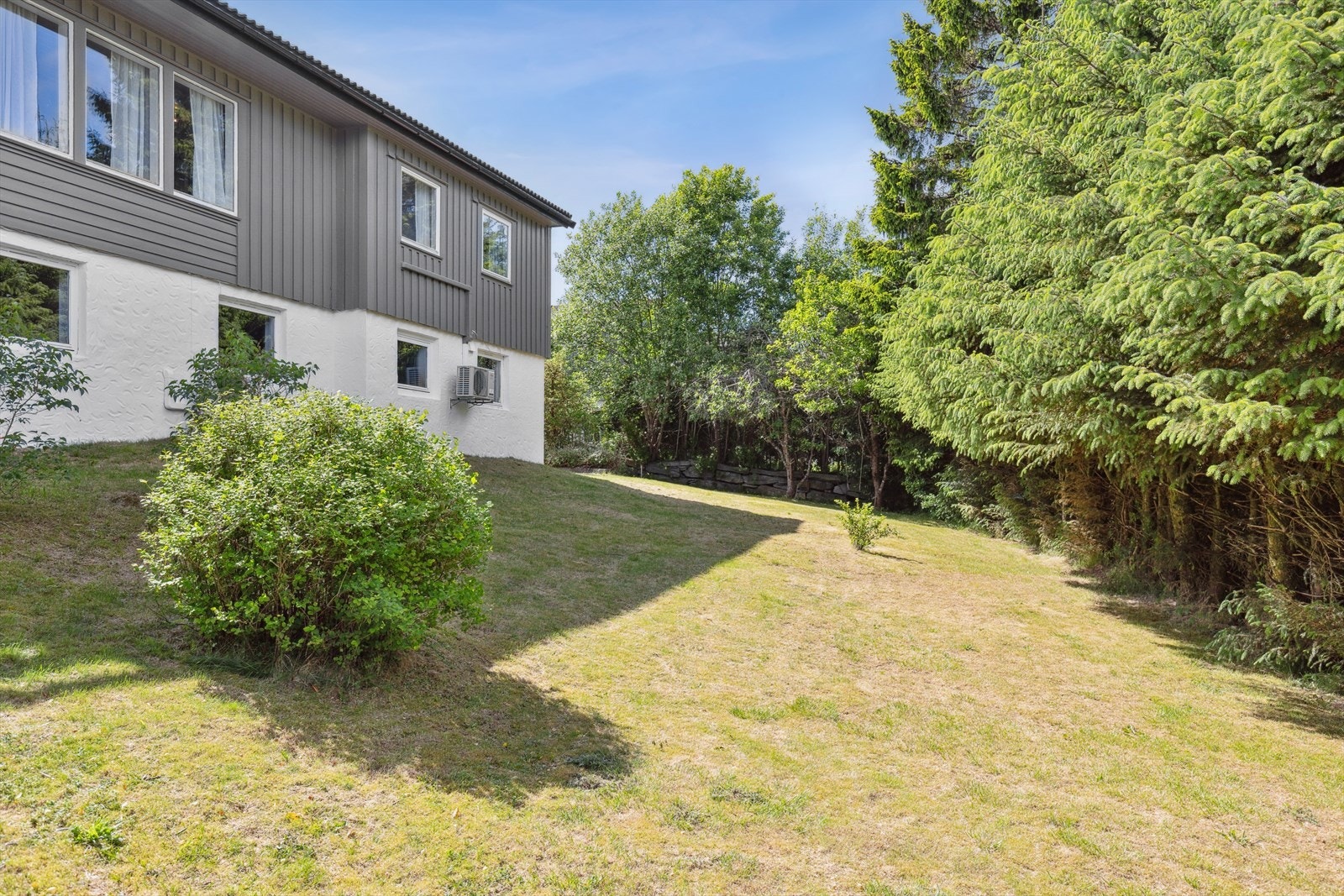 Usjenert hage med plen og beplantning - ideell for lek, hageprosjekter eller en stille stund i solen. Galleribilde