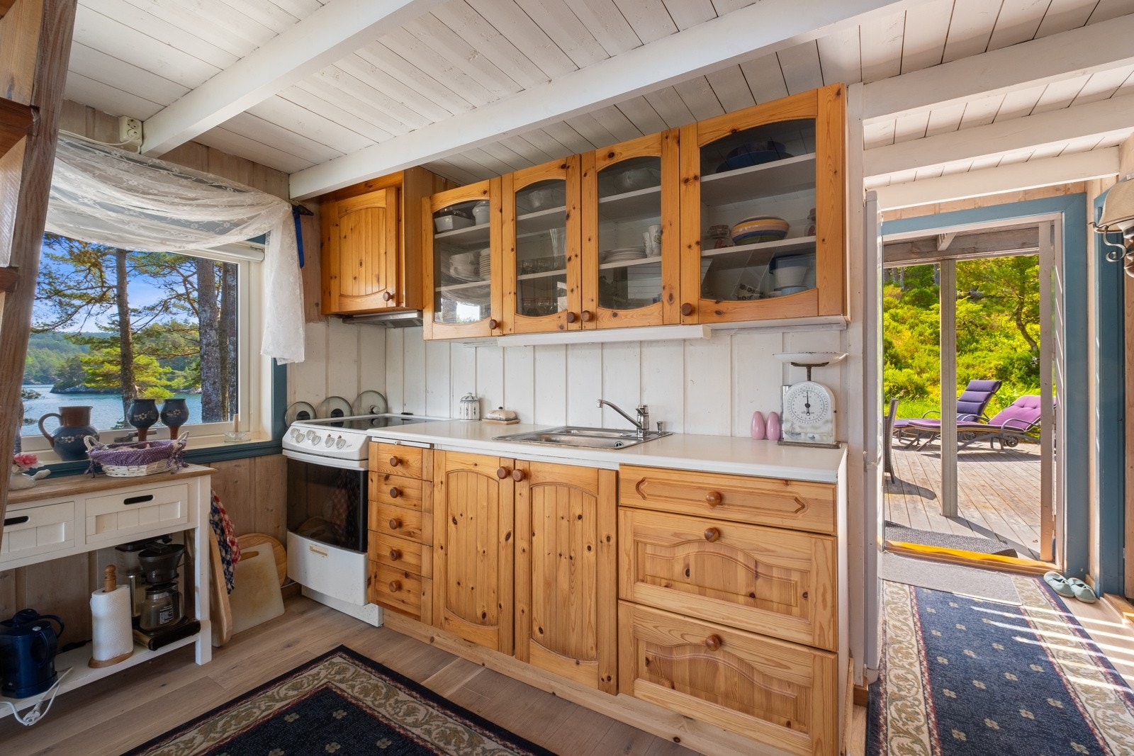 Det er komfyr og kjøkkenventilator med avtrekk ut. Galleribilde