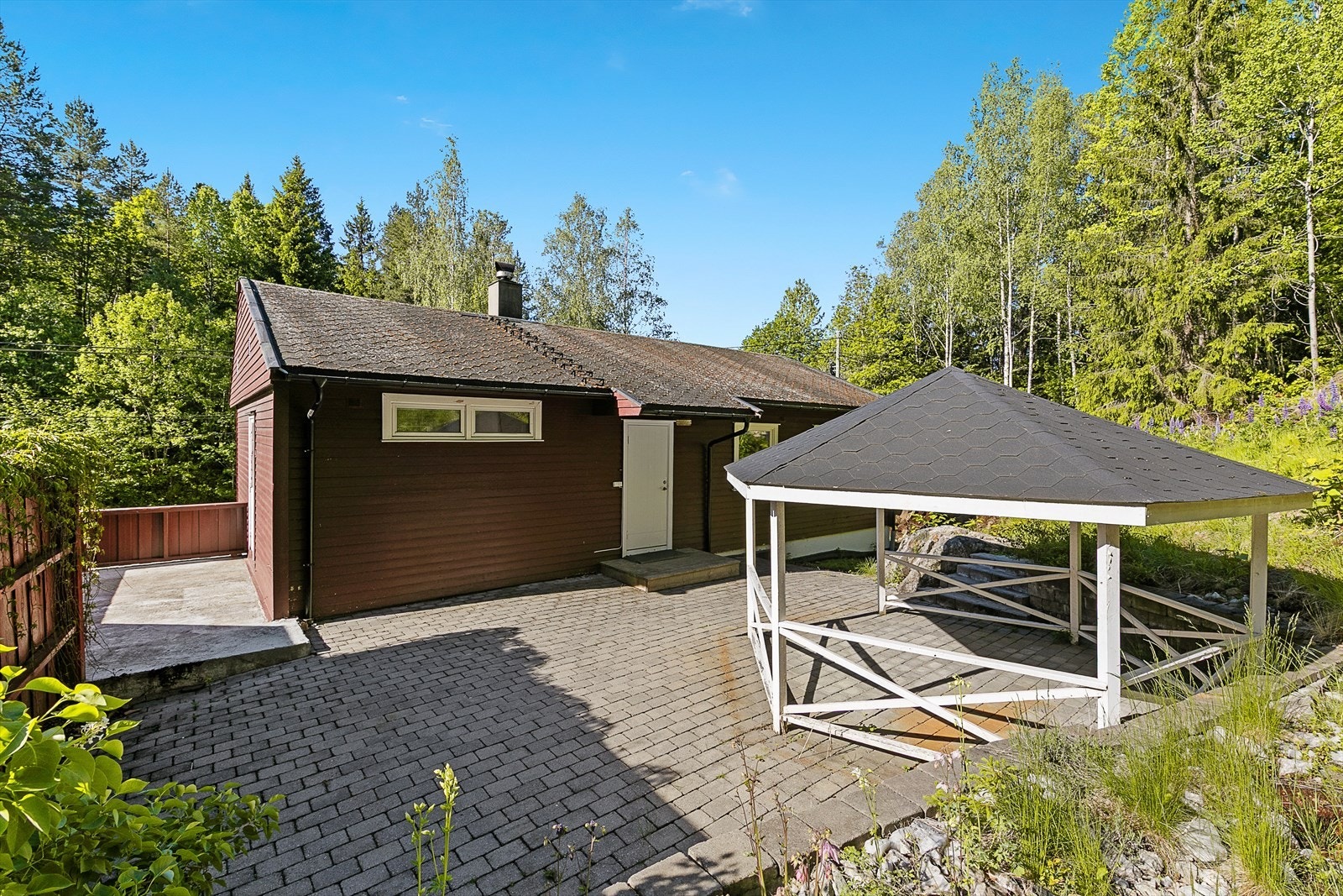 Fra baksiden av huset med uteplass og paviljong Galleribilde