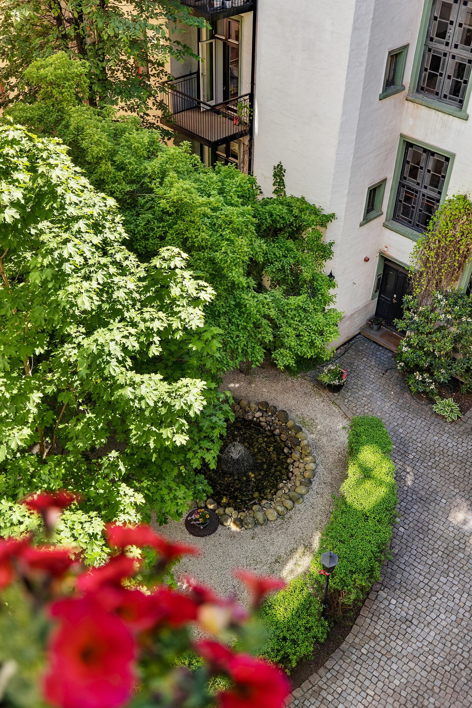 Utsikt ned mot den koselige bakgården fra balkongen. Galleribilde