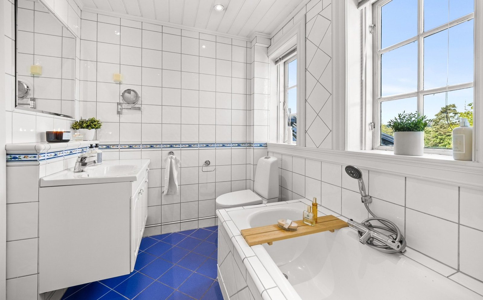 Lyst flislagt bad med badekar. Galleribilde