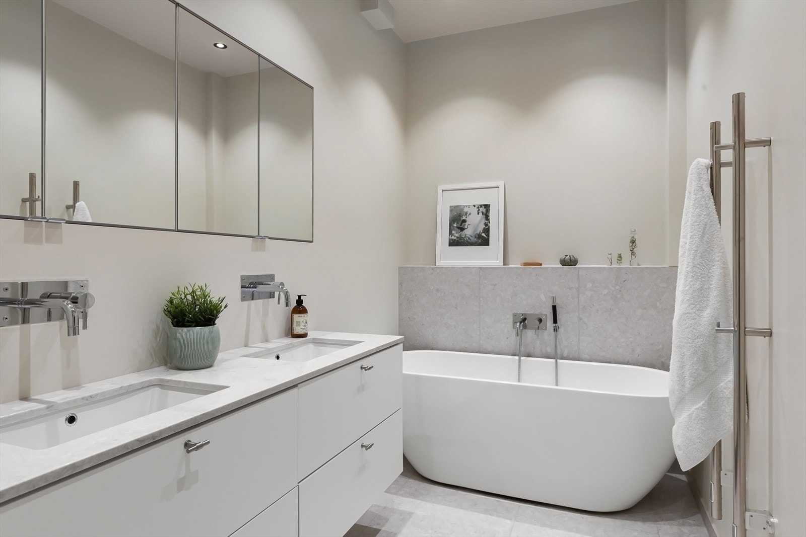 Bad en-suite med badekar, dusjnisje med sittebenk, 2 håndkletørkere og innebygget armaturer fra Tapwell. Vegghengt toalett. Galleribilde