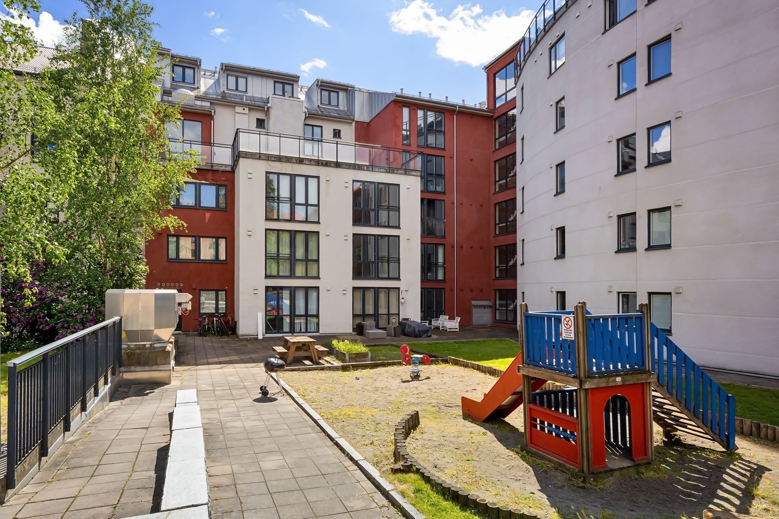 Lukket bakgård med lekeapparater, sykkelparkering og sittegrupper. Galleribilde