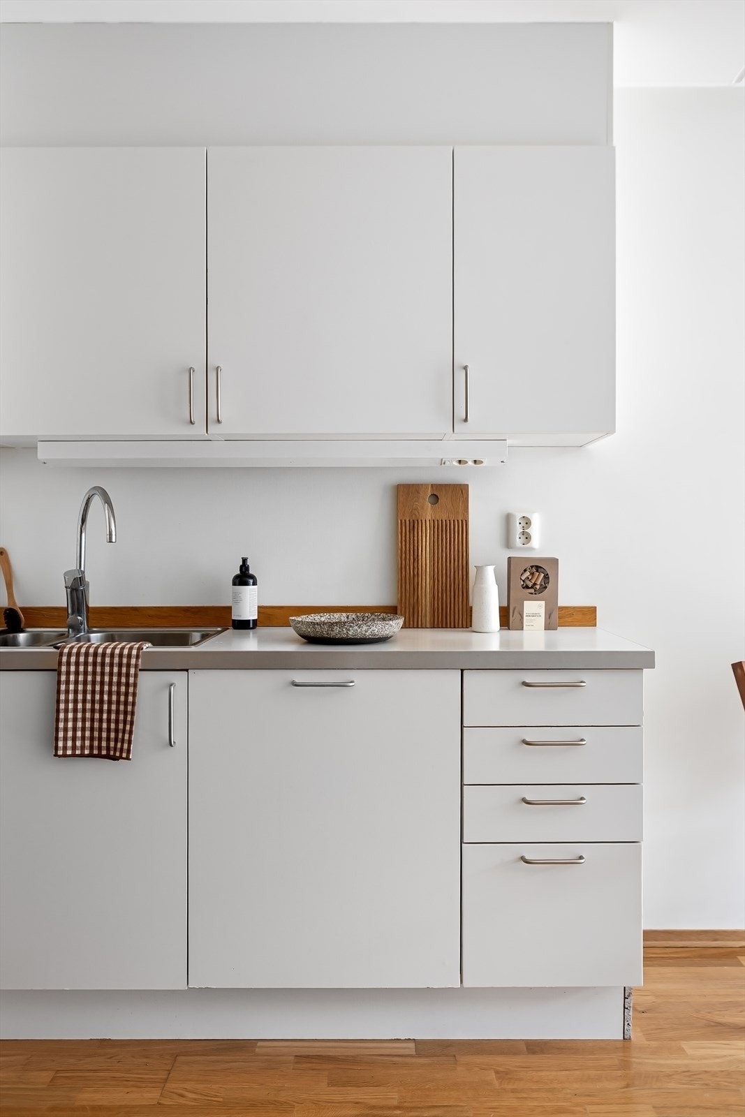 Lys innredning fra 2010 med hvite, glatte fronter og benkeplate i laminat. Galleribilde