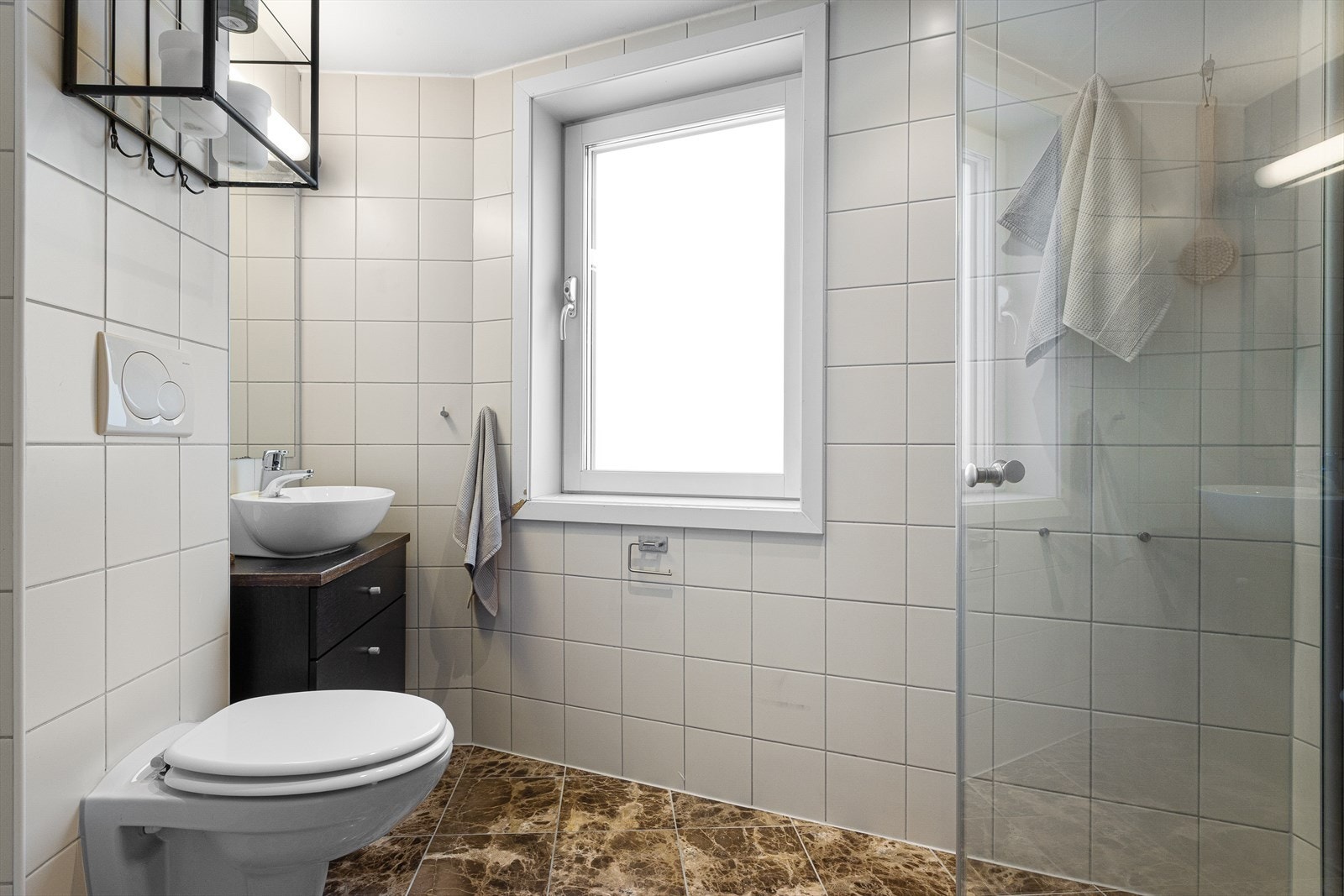 Praktisk bad fra 2010 med flislagte overflater, elektrisk gulvvarme og downlights i himling. Opplegg for vaskemaskin. Galleribilde