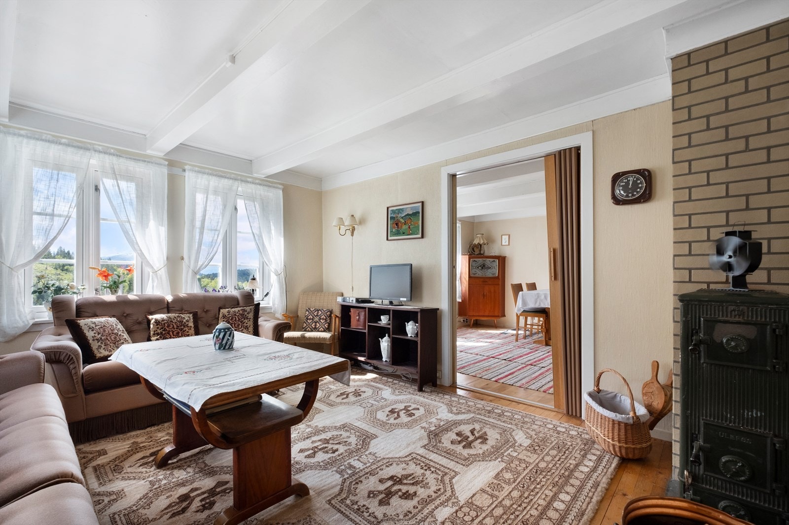 God plass til sittegruppe og Tv-benk på stue. Vedovn. Galleribilde