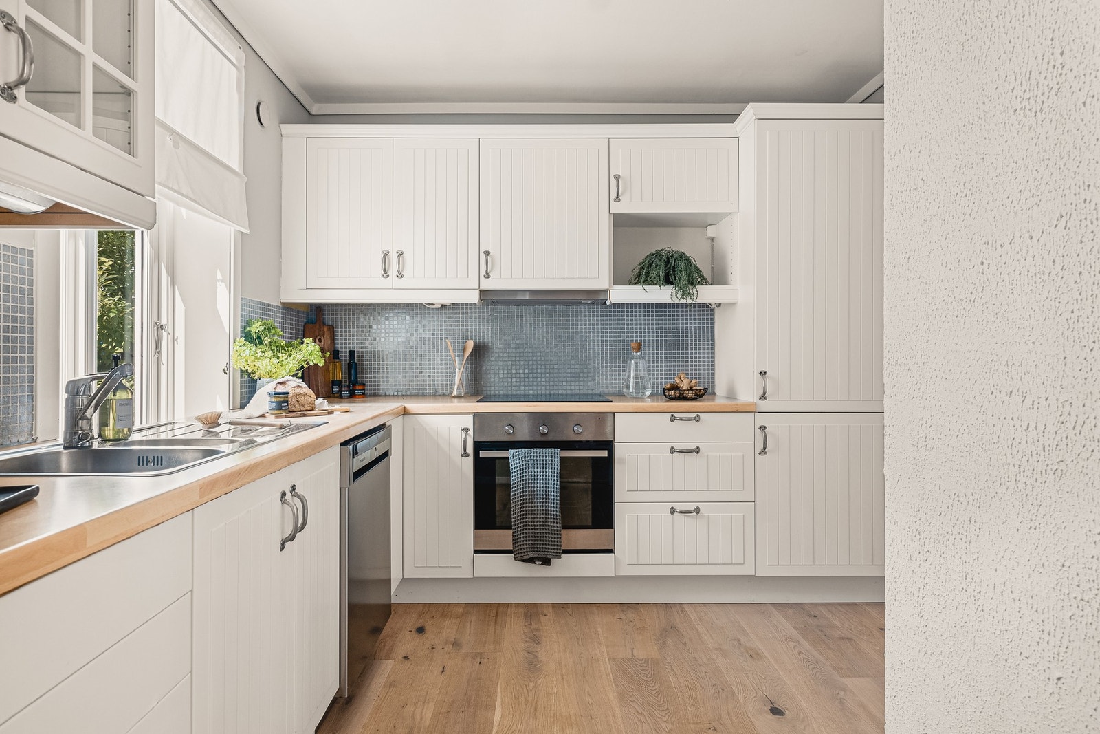Her er det rom for både matlaging og hverdagslige måltider. Innredningen består av profilerte fronter, ettglasskap og en slitesterk laminat benkeplate. Galleribilde