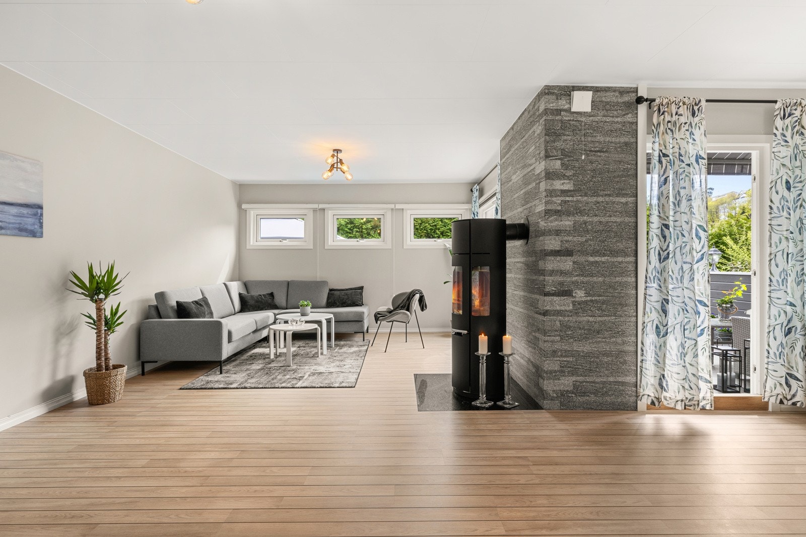 Boligen har en lys og innbydende stue med store vindusflater som slipper inn rikelig med naturlig dagslys og skaper en luftig atmosfære. Galleribilde