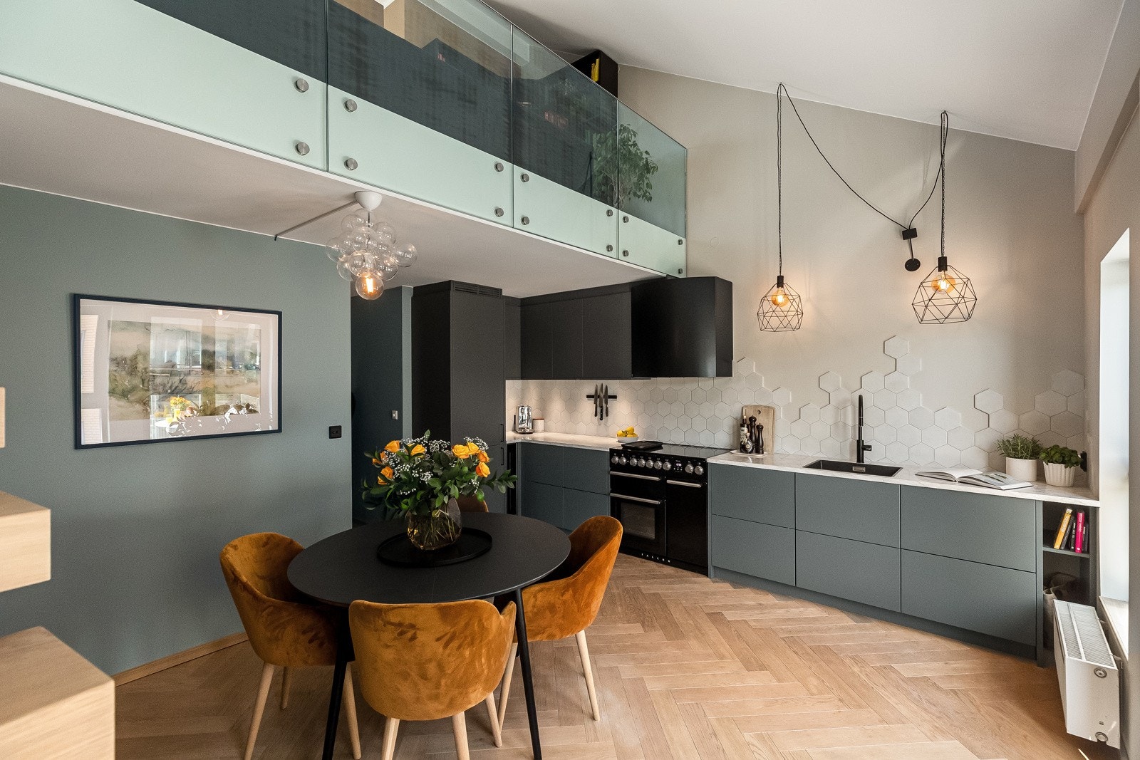 Kjøkkeninnredningen har glatte mørk grå fronter, lekker benkeplate av ekte marmorstein med planlimt kum i svartfarget kompositt, belysning (downlights) under overskap og dekorativt sekskantede fliser på vegg over kjøkkenbenk. Galleribilde