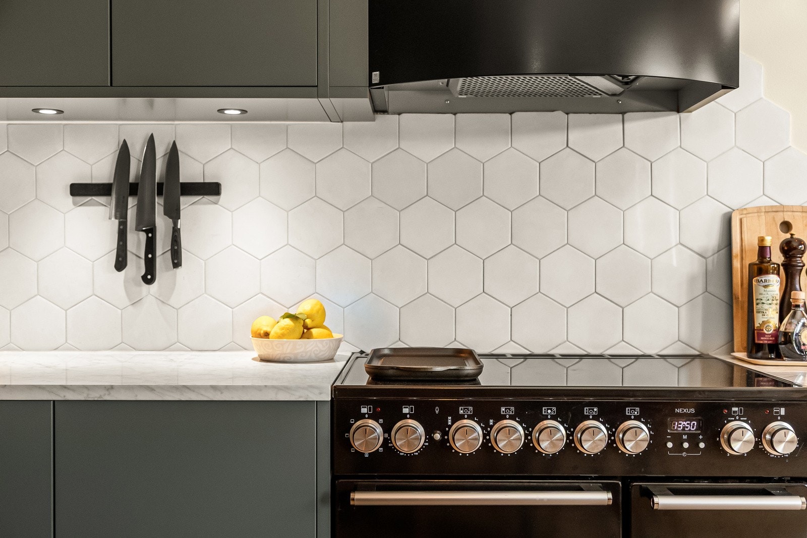 Kjøkkenet har dekorative, sekskantede fliser på vegg over kjøkkenbenk. Galleribilde