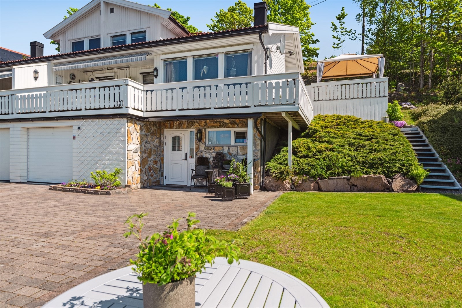 Det er koselig og frodig hageområde i forbindelse med inngangspartiet. Her kan en enkelt innrede med utemøblement eller trampoline, alt etter ønske og behov. Galleribilde