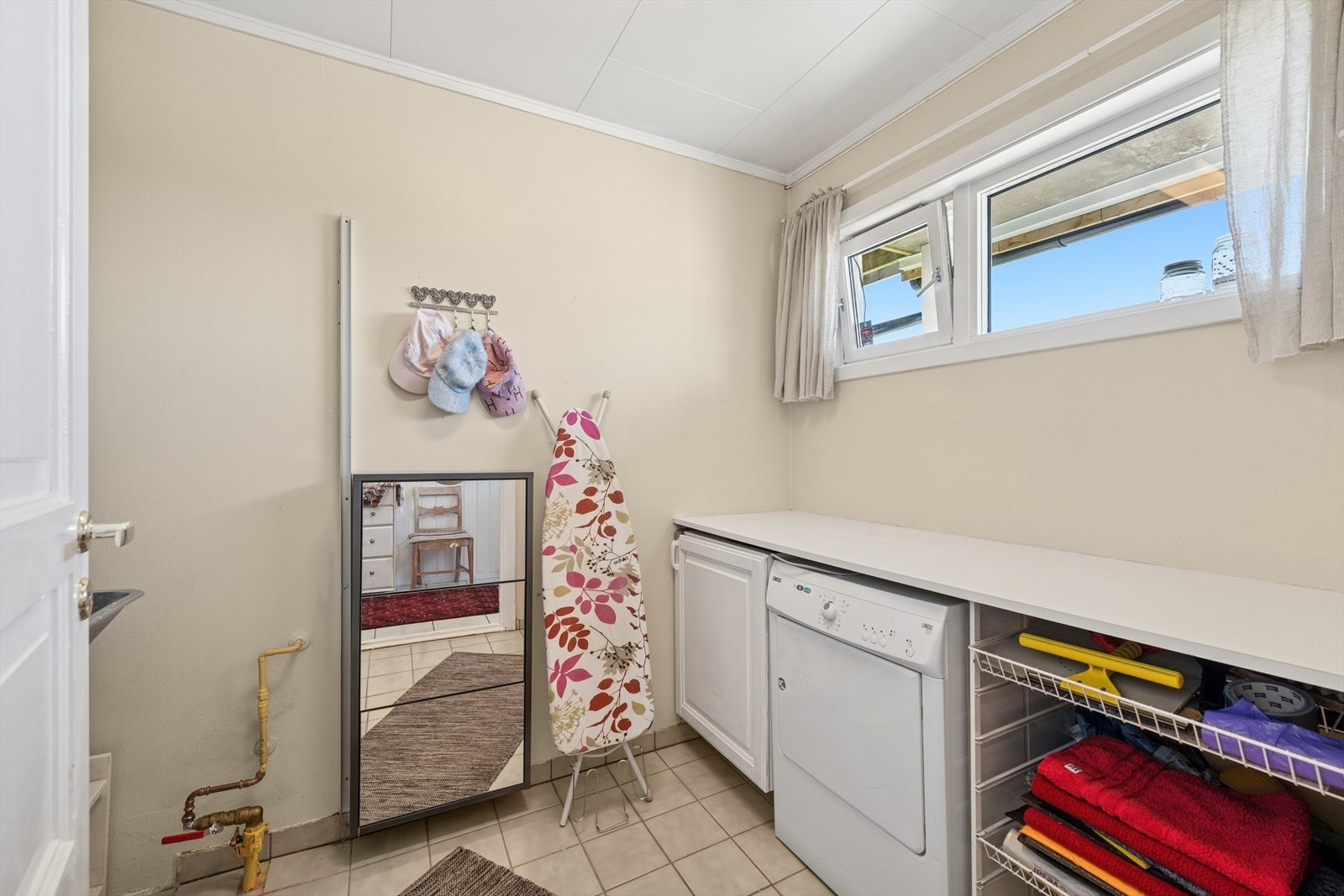 Eget vaskerom som er gjennomført med flislagt gulv og vegger med malt strietapet. Rommet er innredet med stor utslagsvask, benkeplass for fint arbeidsareal og opplegg for vaskemaskin. Et slik rom er uvurderlig i en hektisk hverdag! Galleribilde