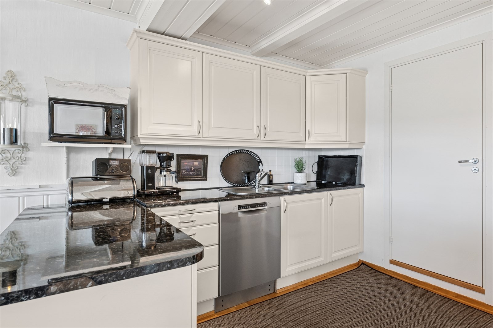 Det er montert en klassisk og tidløs kjøkkeninnredning i lys utførelse med god benk- og skapplass og med innredning på begge sider av rommet med egen kjøkkenøy. Galleribilde