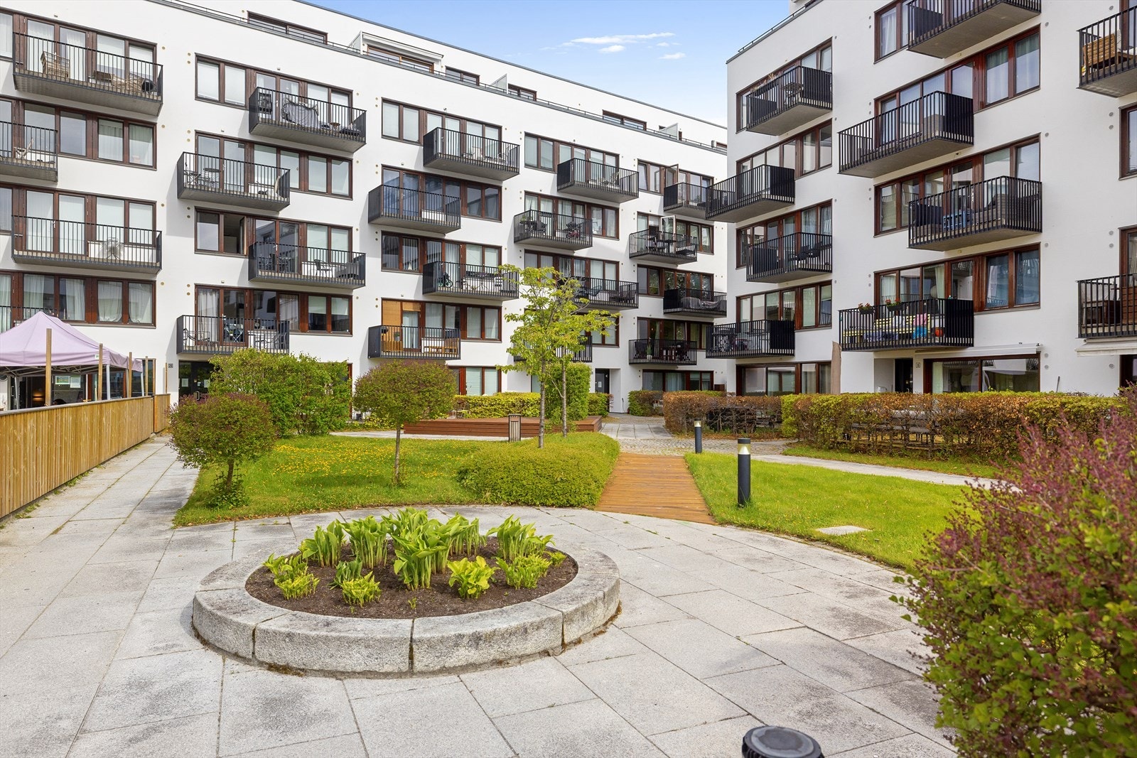 Bakgården er pent opparbeidet med fine sittegrupper, trær og pen beplantning. Galleribilde