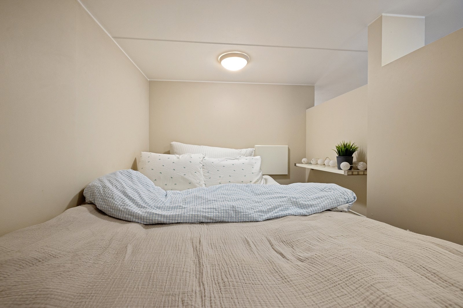 Det er vegghengt dobbeltseng med nattbord. Galleribilde