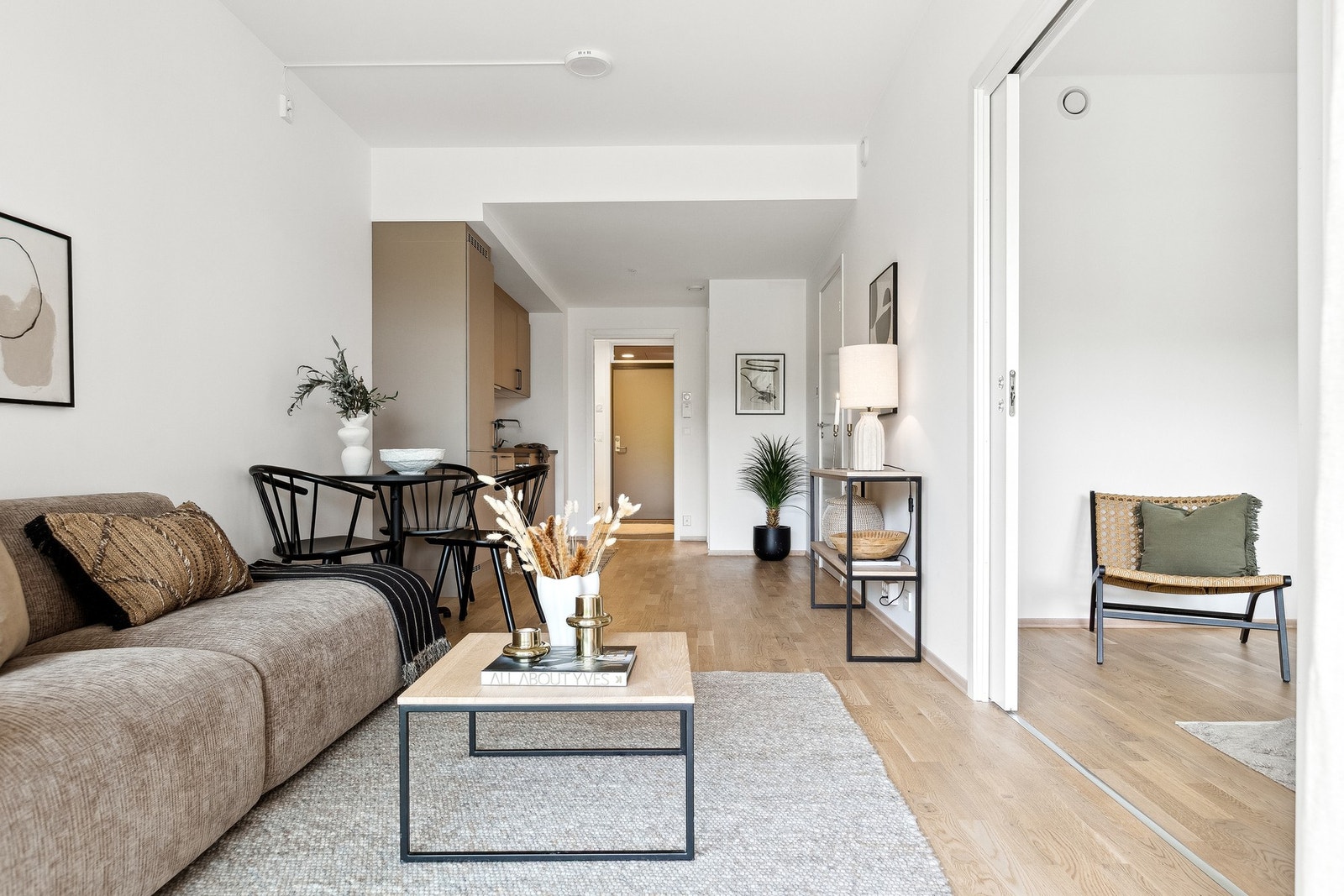 Åpen stue/kjøkken-løsning med natulig oppdeling med spisegruppe i mellom. Galleribilde