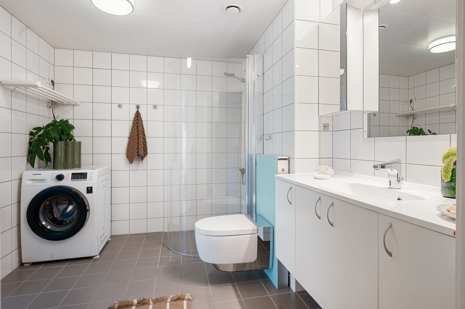 Rommet er innredet med vegghengt klosett, servant med innredning og dusjhjørne med glassdører. Det er inngang til bad både fra gang og hovedsoverom. Galleribilde