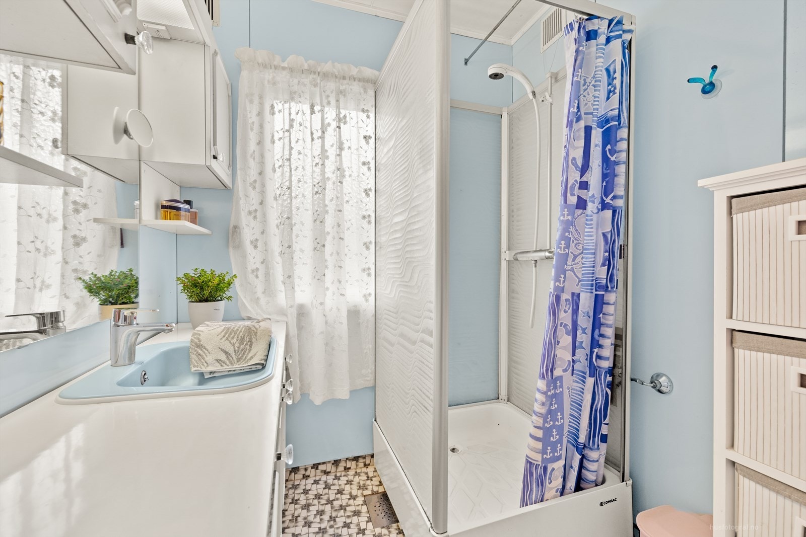 Enkelt bad med dusjkabinett og innredning med servant. Galleribilde