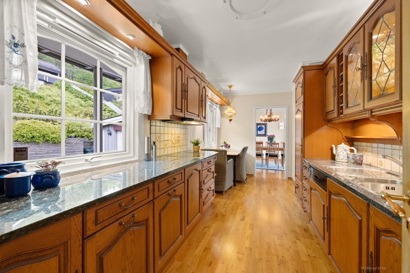 Profilert innredning på kjøkken i eik med eksklusive benkeplater av stein Galleribilde