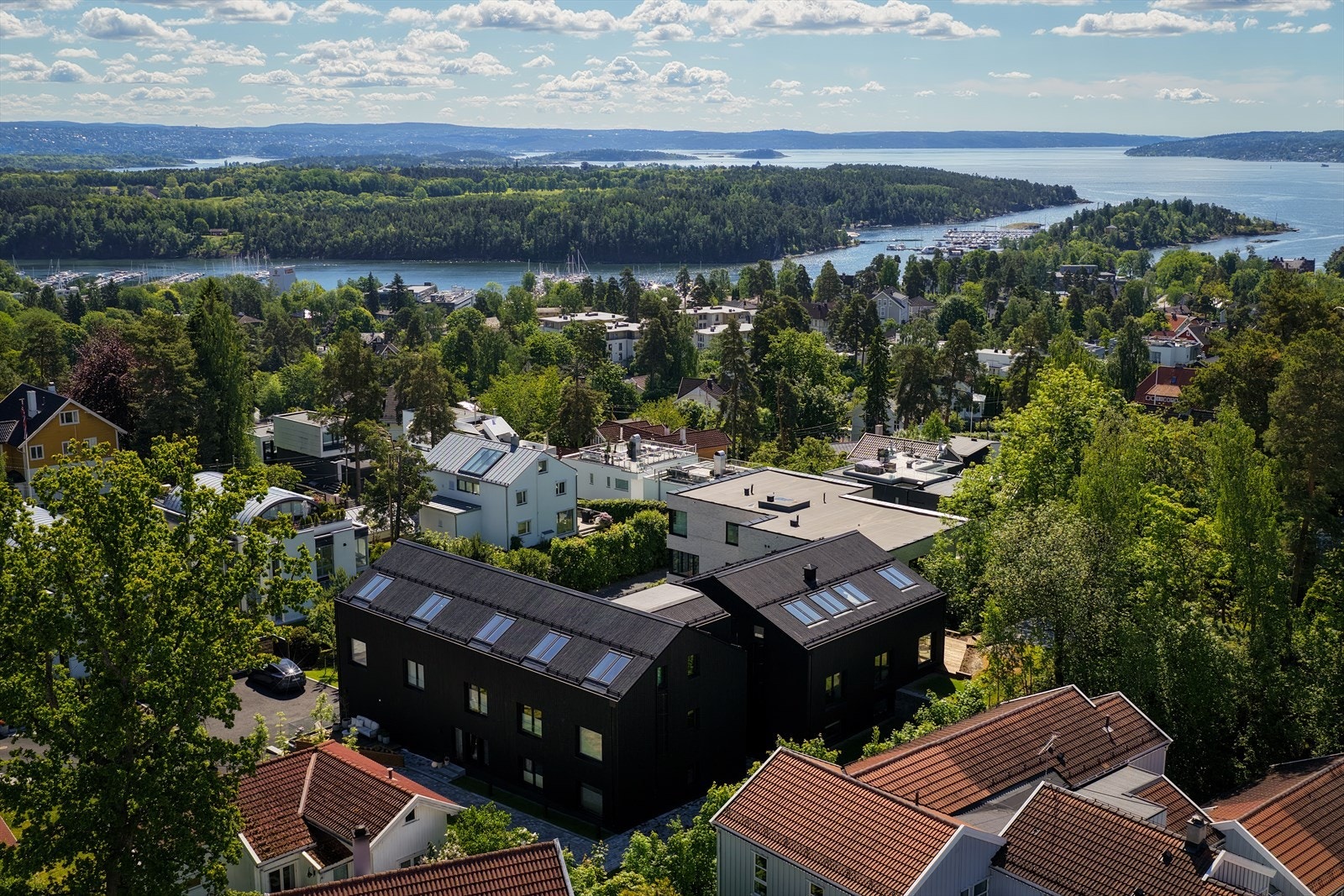 Her finner man flotte gang- og sykkelstier som strekker seg langs vannet, perfekte for både trening og rekreasjon - Om sommeren kan man også nyte bading og båtliv i fjorden Galleribilde