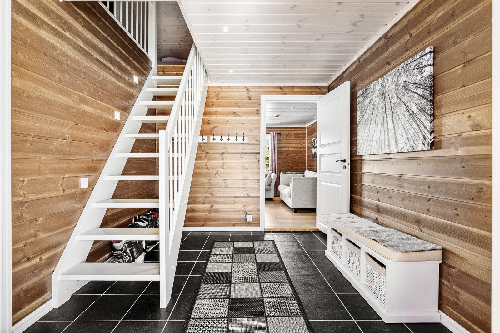 Her blir du møtt av en åpen og flott hall med flislagte gulv med varmekabler. Gulvet står i stil til de litt mørkere veggene og skaper en flott atmosfære av en fjellhytte. Galleribilde