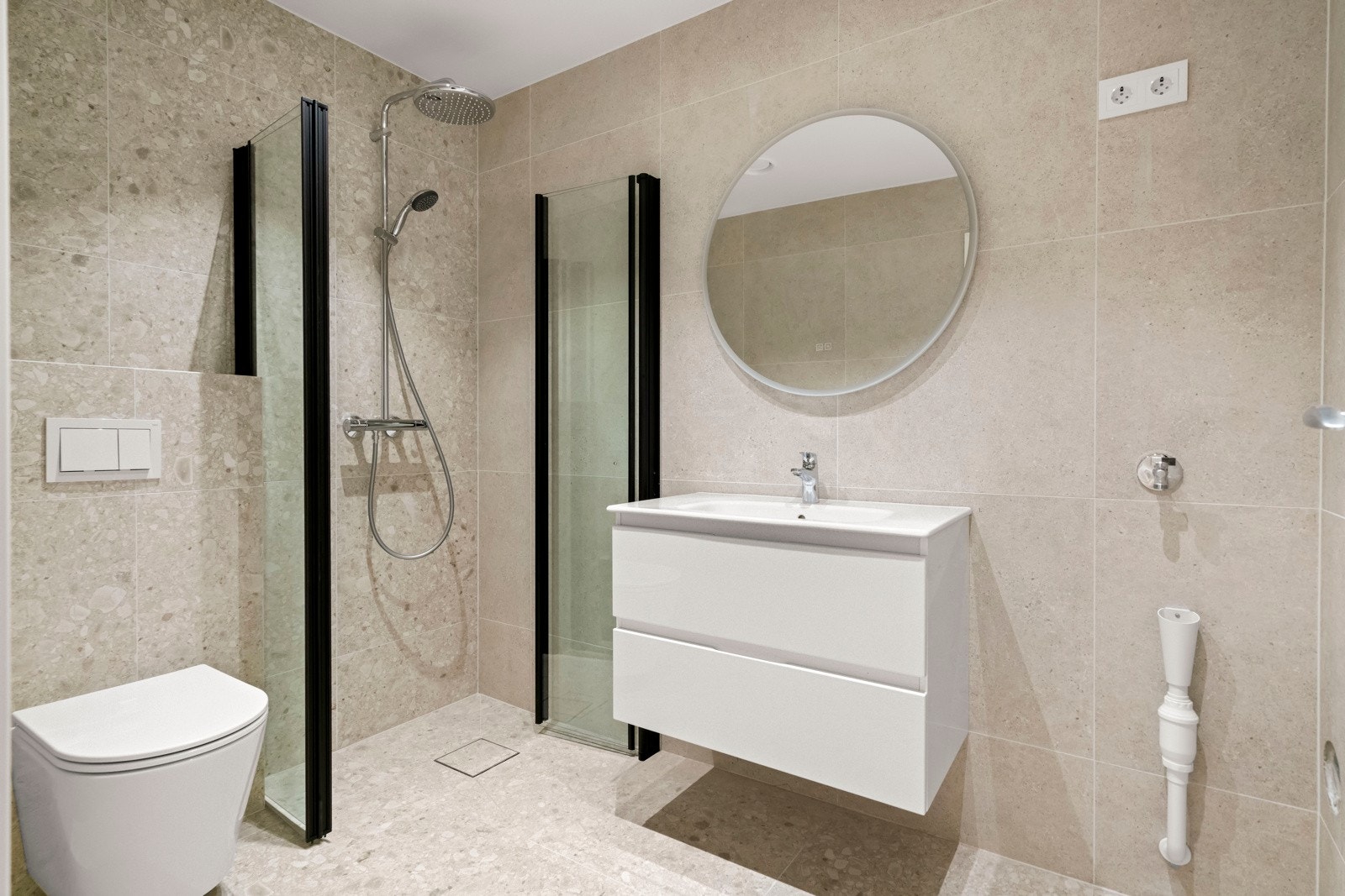 Lekkert baderom i kjeller med toalett, dusj, servant og skapinnredning. Galleribilde