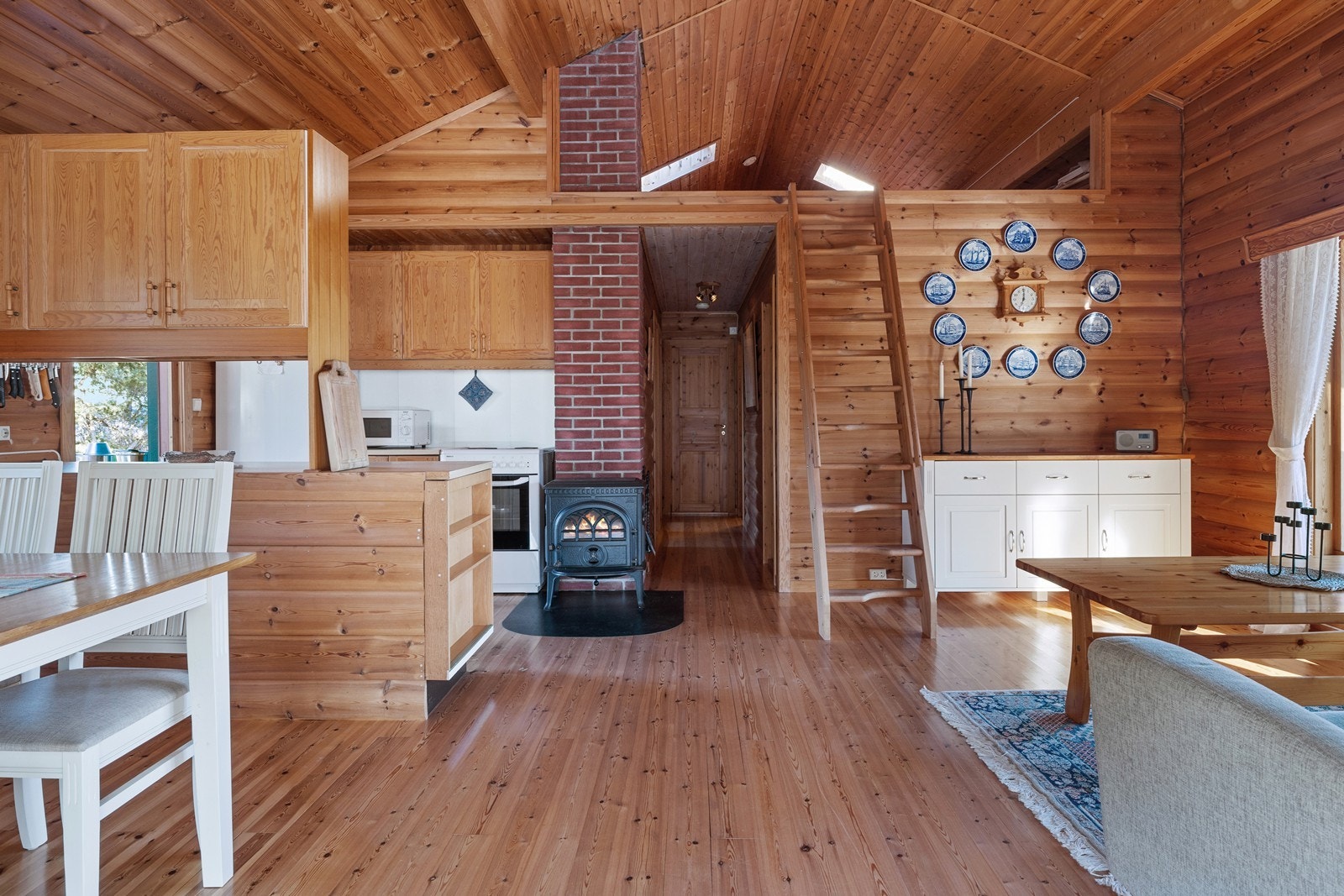 Åpen løsning mellom stue og kjøkken i tilbygget gir en sosial atmosfære Galleribilde