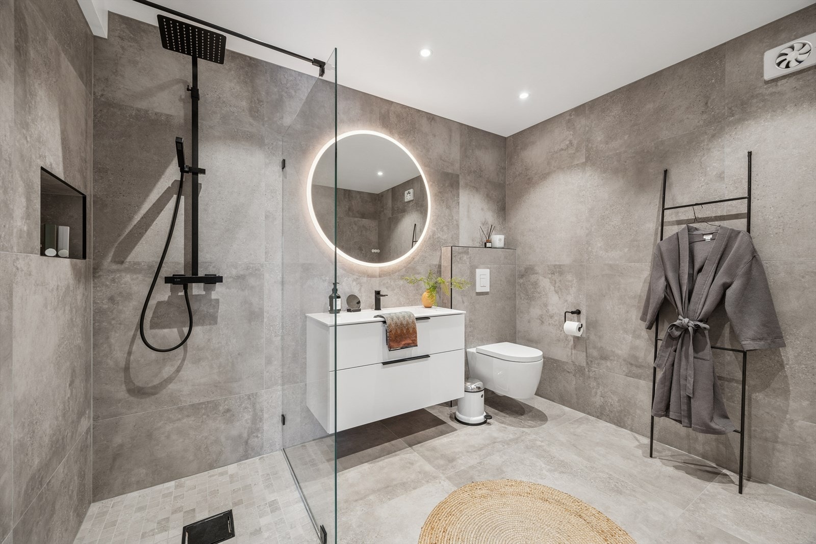 Badet er veldig moderne og tidsriktig med sort armatur og store lekre fliser på gulv og vegg. Galleribilde