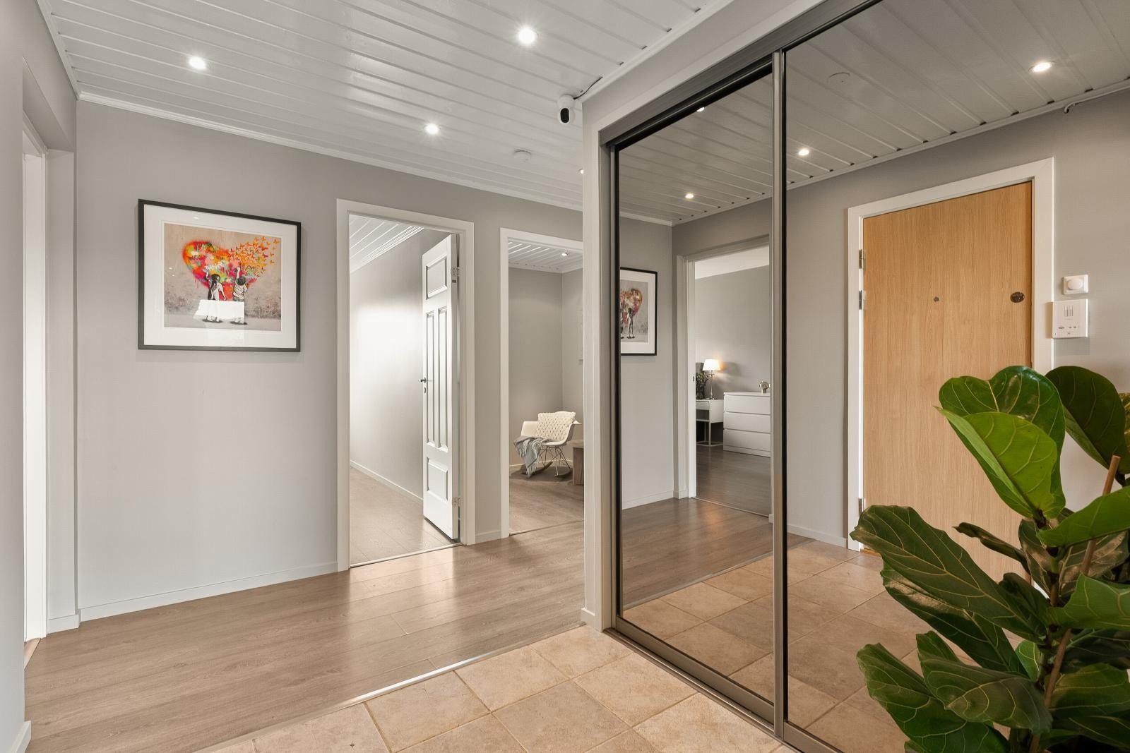 Romslig entré med god oppbevaringsplass i en innfelt skyvedørsgarderobe med speilfronter. Galleribilde