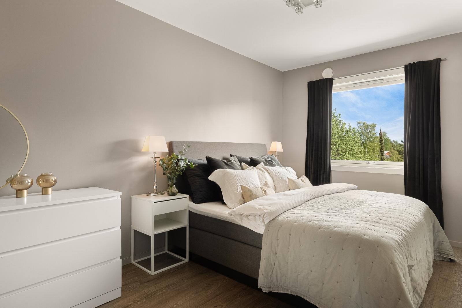 Glatte, malte vegger og enstavs bred laminat på gulvet skaper en moderne og innbydende atmosfære. Galleribilde