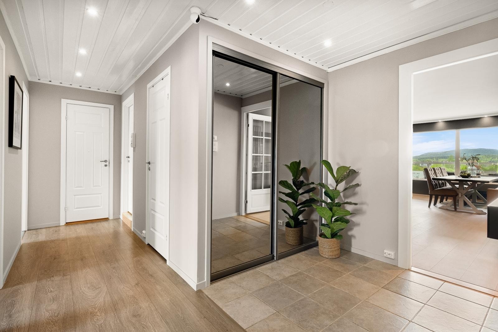 Velkommen inn i en lys og innbydende entré med bred døråpning mot stuen og adkomst til alle fire soverom, bad, toalettrom og en praktisk bod. Galleribilde
