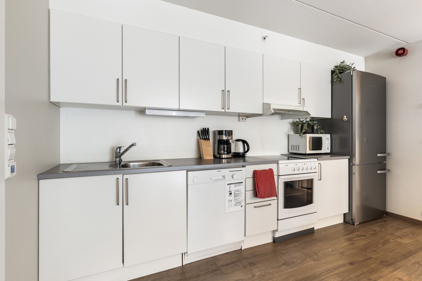 Kjøkkenet er utstyrt med frittstående hvitevarer og laminat benkeplate. Slette, matte fronter. Galleribilde