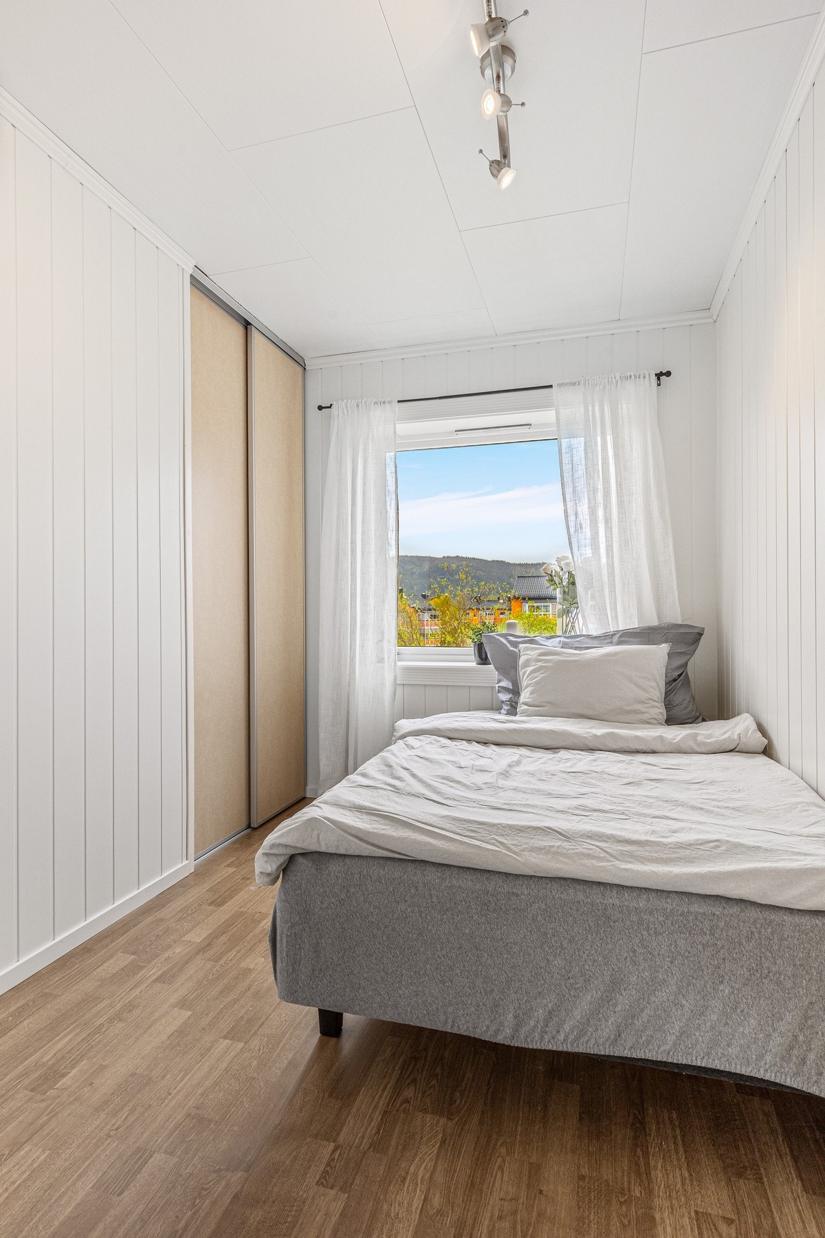 Boligens andre soverom er lyst og fint og har en praktisk skyvedørsgarderobe Galleribilde