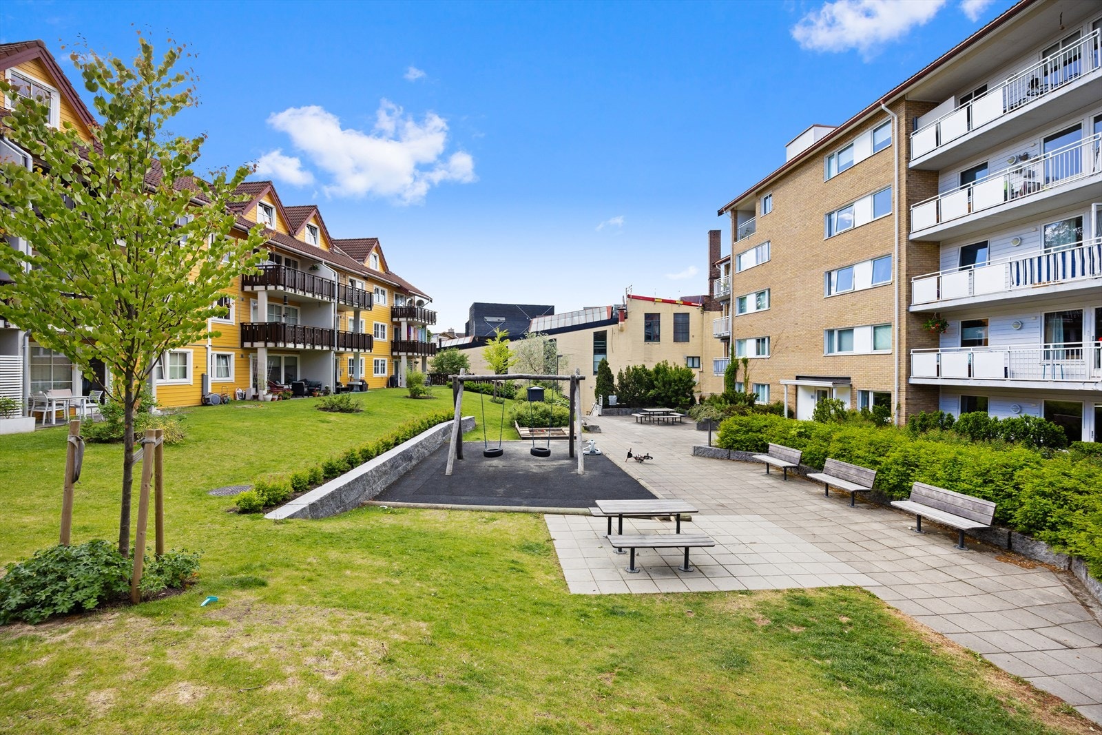 Fellesområde med lekeplass for barn og sitteplasser. Galleribilde