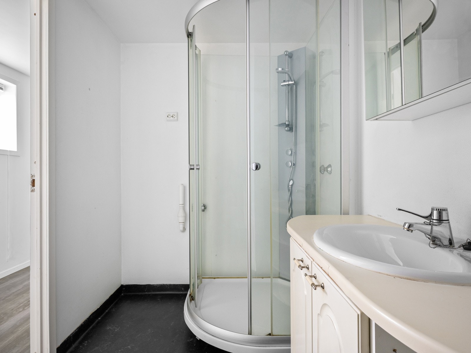 Badet er innredet med baderomsinnredning med vask, dusjkabinett, toalett og opplegg for vaskemaskin Galleribilde