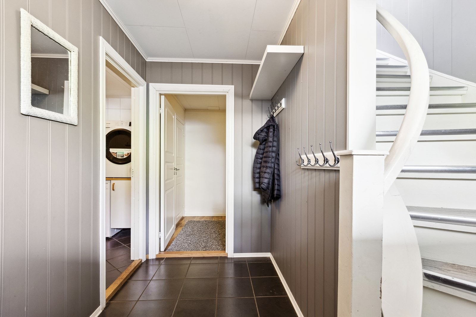 Gang i 1. etasje er i tilknytting til vaskerom, disprom og bod samt trapp som fører til 2. etasje. Galleribilde