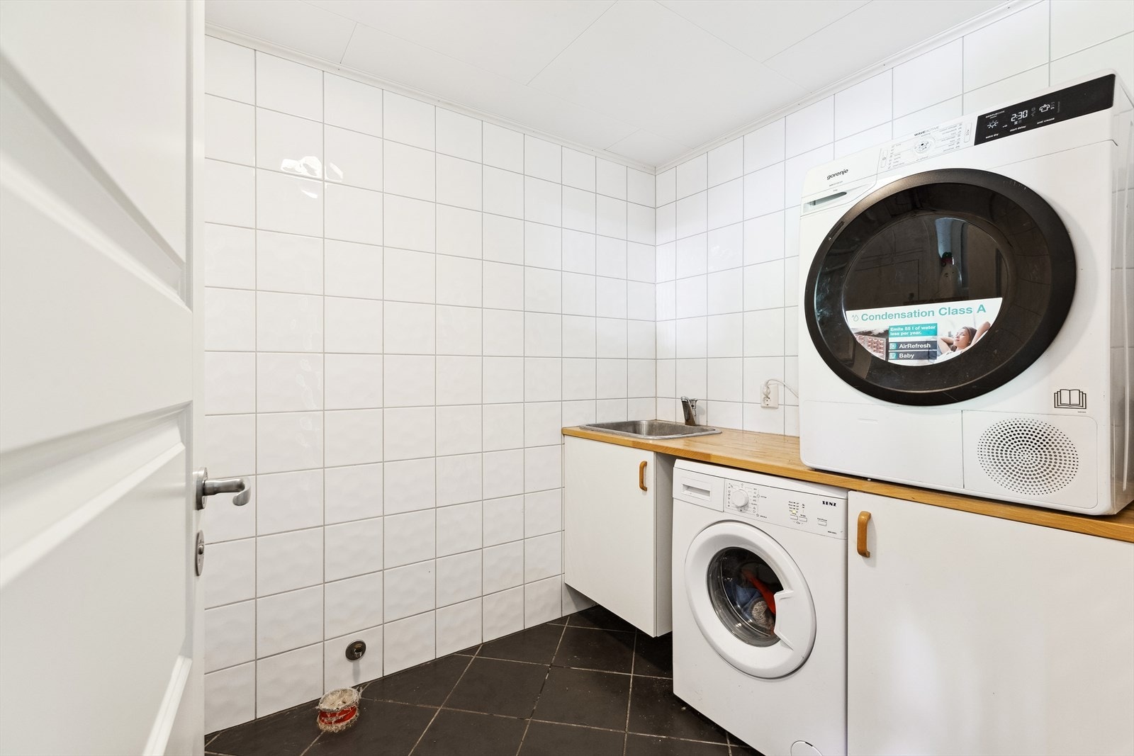 Vaskeromet er utstyrt med bereder, opplegg for vaskemaskin, rørfordelingsskap og skyllekum samt skyllekum i benk med skap. Galleribilde