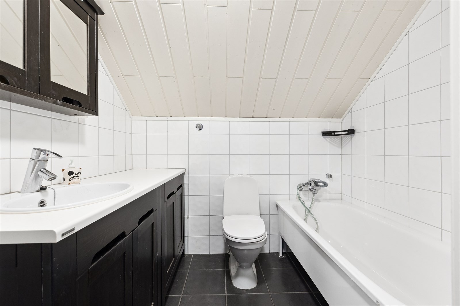 Pent flislagt bad utstyrt med badekar, wc, servant, servantskap og naturlig avtrekk. Galleribilde