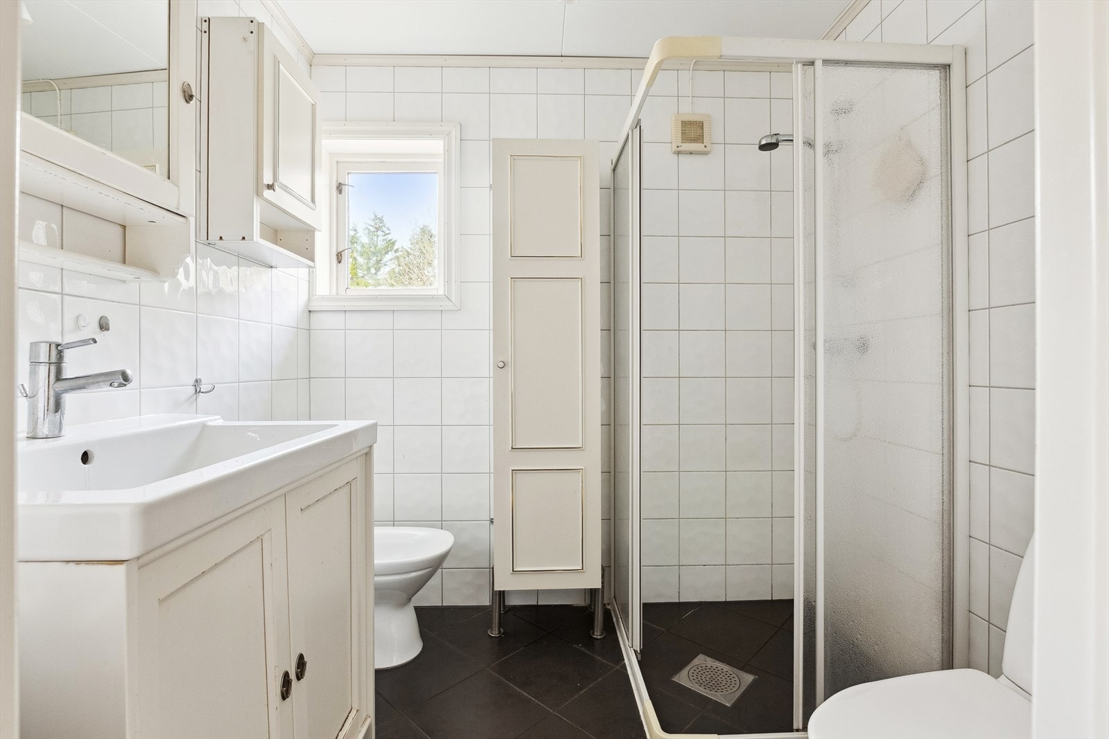 Boligen har to pene og flislagte bad. Her er badet utstyrt med dusjhjørne, bidé, wc, servant, servantskap og mekanisk avtrekk. Gulvvarme. Galleribilde