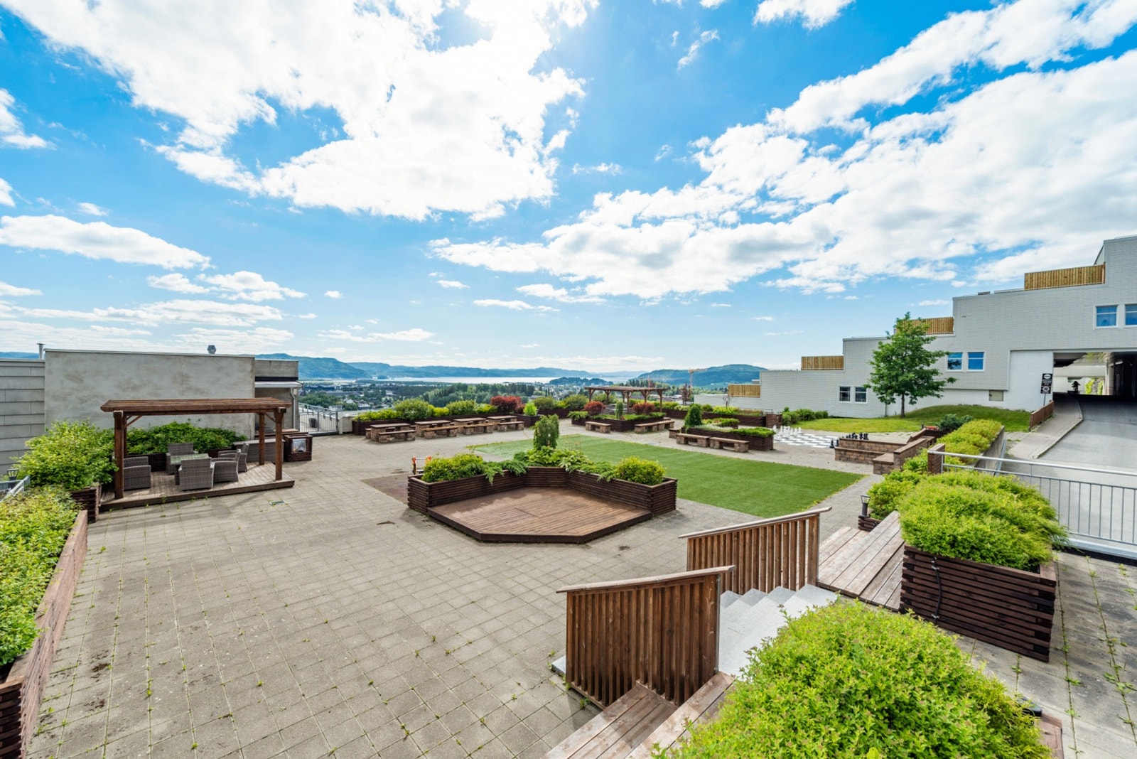 Stort fellesareal på byggets takterrasse med boltreplass for både store og små. Galleribilde