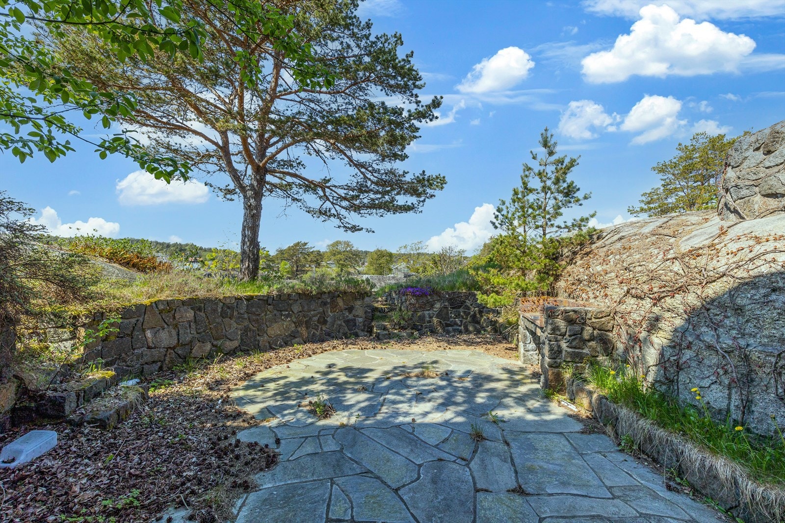 Terrassen utenfor kjellerstuen er rammet inn av stablet mur, noe som gjør den ekstra lun og privat. Galleribilde