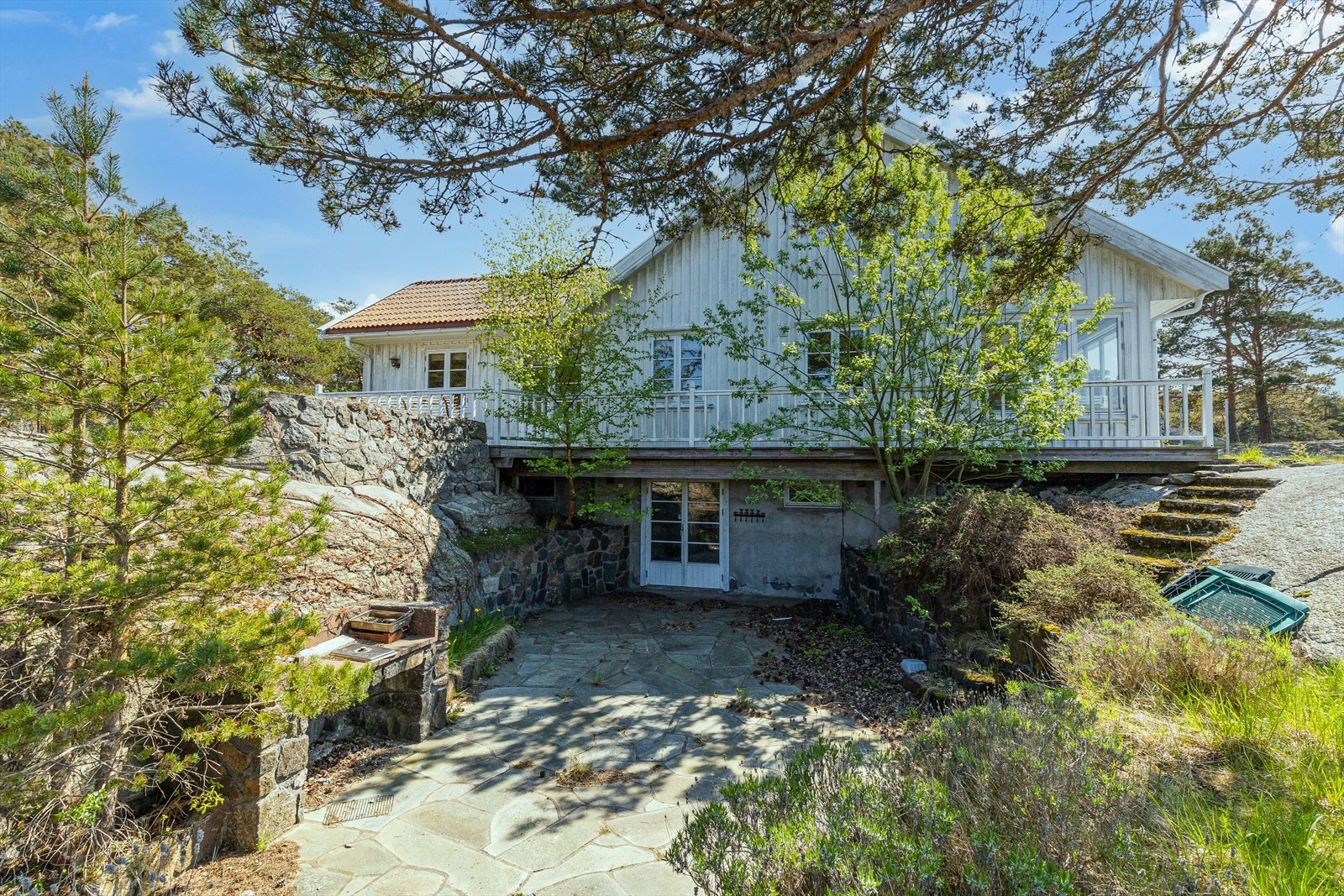 Kjelleren har tre soverom, bad/vaskerom, to boder, og en stor kjellerstue med peis og utgang til skjermet terrasse. Galleribilde