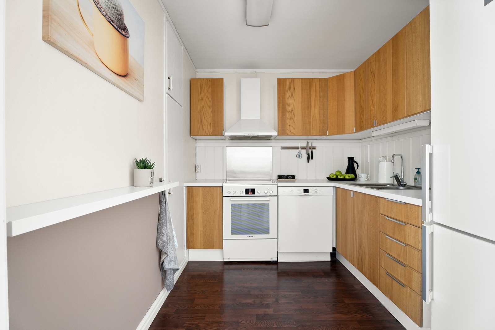 Kjøkkeninnredning med fronter med trestruktur og laminat benkeplate Galleribilde