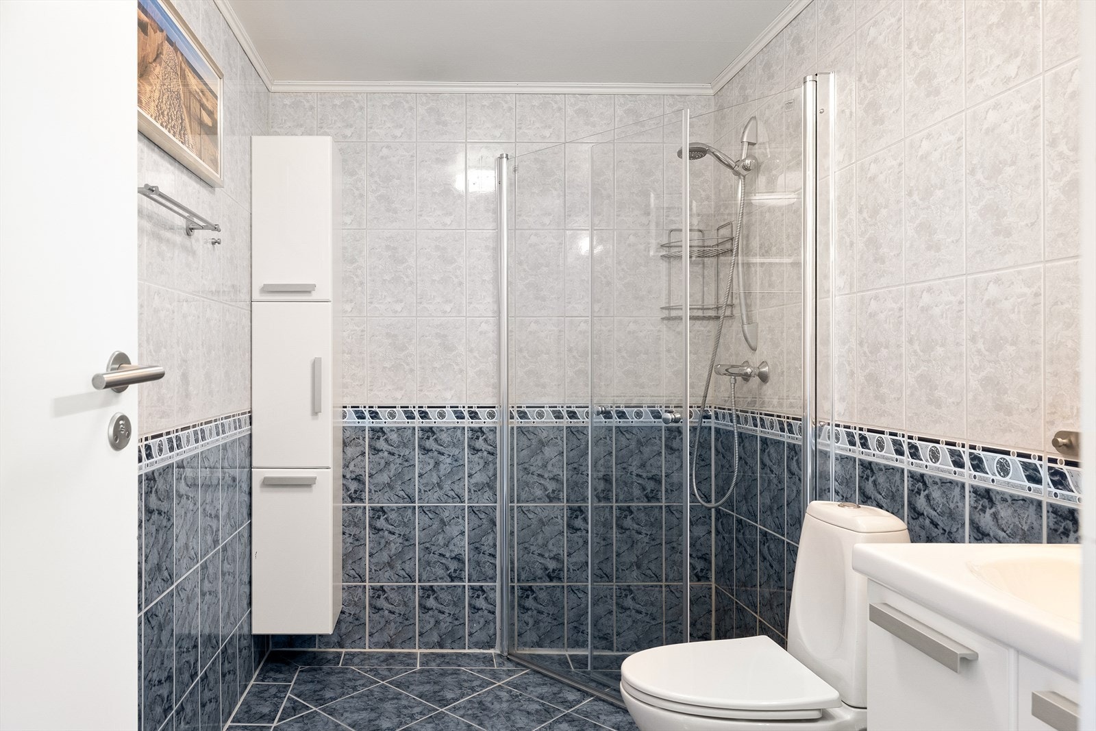 Funksjonelt og romslig bad med flislagte overflater på gulv og vegger, samt varmekabler i gulvet. Galleribilde