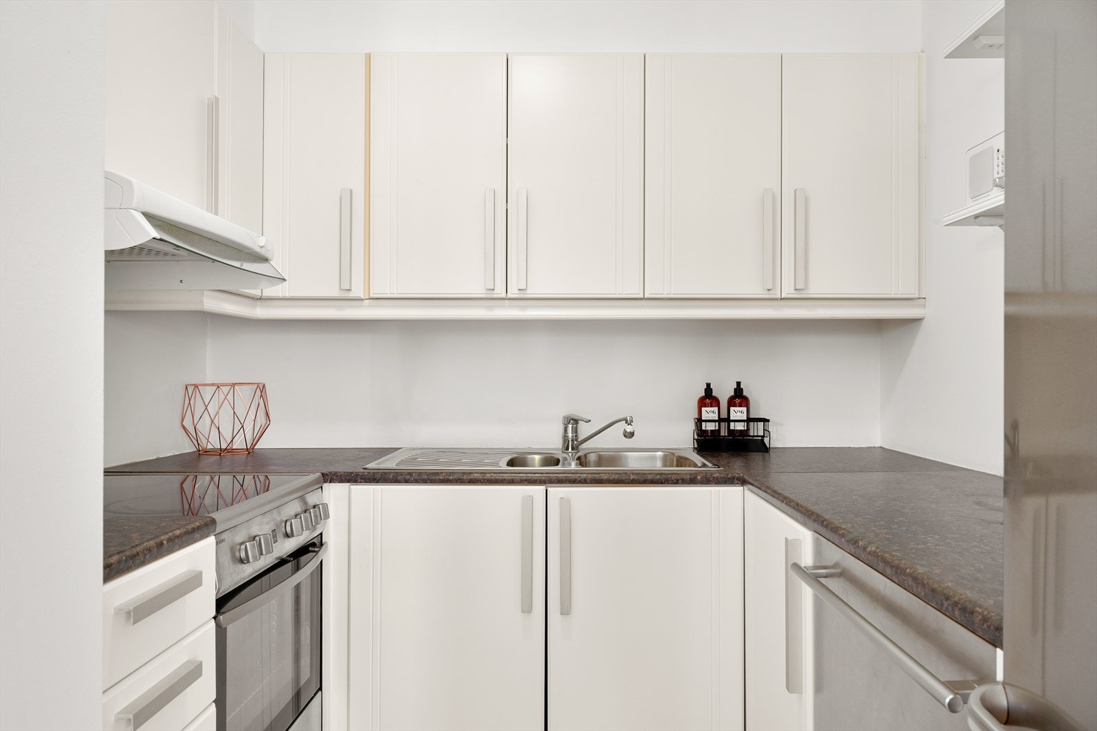 Kjøkkenet ligger i tilknytning til stuen og har en lys og enkel utførelse med hvite fronter som gir et rent og tidløst uttrykk. Galleribilde